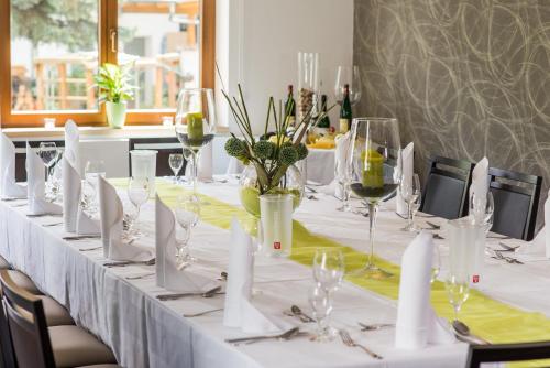 a long table with white table cloths and wine glasses at B&S Hotel Am Bachhaus in Eisenach