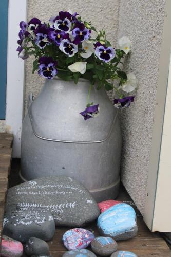 a gray vase with purple and white flowers in it at Stóri-Bakki Guesthouse-with hot tub in Egilsstadir