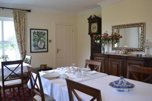 a dining room with a table and a mirror at Guaire House Killarney in Killarney