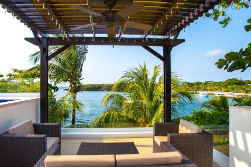 a patio with chairs and a view of the water at Bella Luna Beach Home #64708 in West End