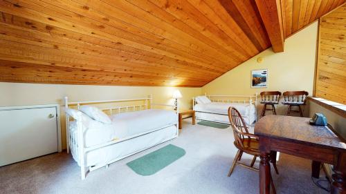 una sala de estar con muebles blancos y techos de madera. en Snowflower #81 Condo, en Mammoth Lakes