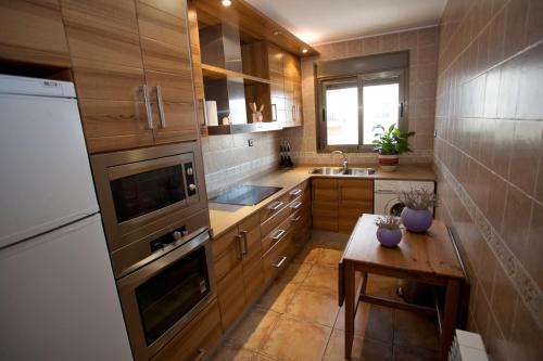 a kitchen with wooden cabinets and a table in it at Apartamentos Maribel in Calaceite