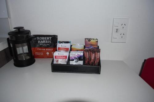 a table with books and a candle and a coffee mug at Carramar Motor Inn in Palmerston North