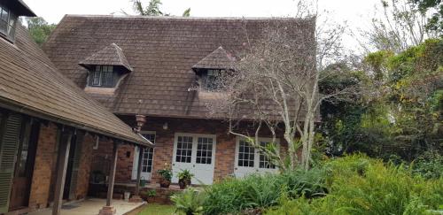 an old brick house with windows and a roof at Belle Vue Park Villa in Mount Tamborine