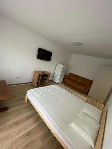 a bedroom with a large white bed and a couch at Mangalia Port in Mangalia
