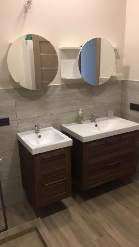 a bathroom with two sinks and two mirrors at EVA HAUS in Nemėžis