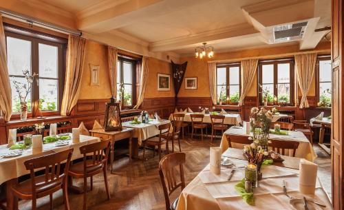 ein Restaurant mit Tischen, Stühlen und Fenstern in der Unterkunft Gasthof Weißes Roß in Kleinostheim