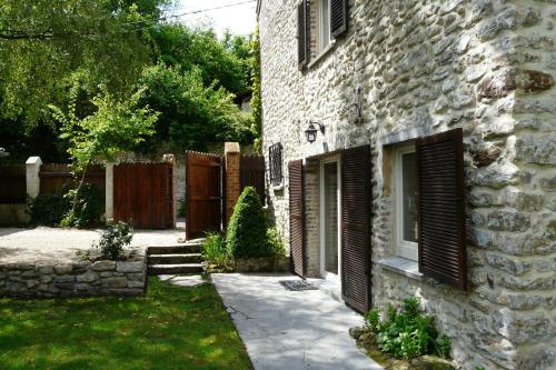 a stone house with a yard next to a fence at B&B Le Valangré in Chaumont-Gistoux