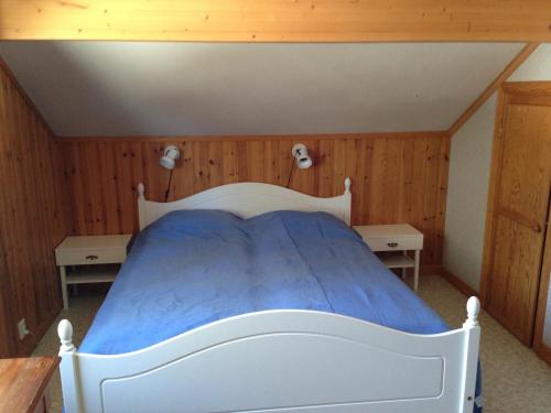 a bedroom with a white bed with two tables at Hansjö Stugby - Mickolavägen in Orsa