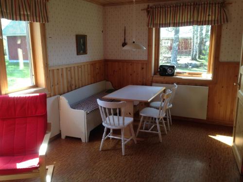 Habitación con mesa, sillas y ventanas. en Hansjö Stugby - Mickolavägen, en Orsa