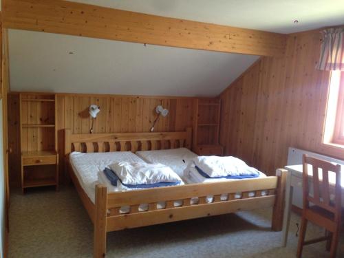 1 dormitorio con 1 cama grande y paredes de madera en Hansjö Stugby - Mickolavägen, en Orsa
