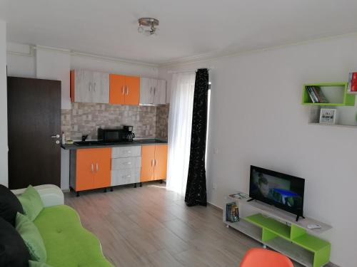 sala de estar con armarios de color naranja y cocina en AMA Apartament cu terasă 50 mp & parcare en Brasov