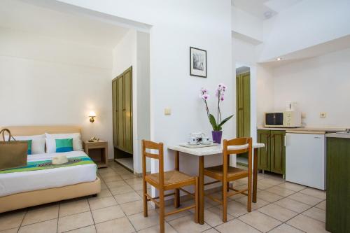 a hotel room with a bed and a table and chairs at Royal Aparthotel City Centre in Rhodes Town