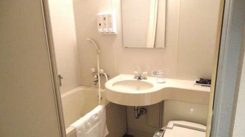 a bathroom with a sink and a toilet at Green Rich Hotel Nishitetsu Ohashi Ekimae in Fukuoka