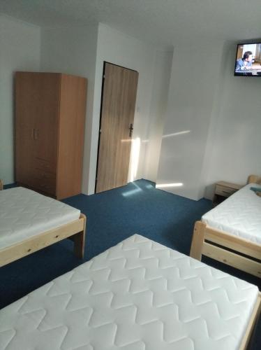 an empty room with two beds and a door at Ubytování MV Týn nad Vltavou - Bohunice - Temelín. in Týn nad Vltavou