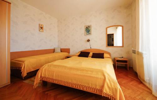 a bedroom with two beds and a mirror at Apartments Lina in Novi Vinodolski