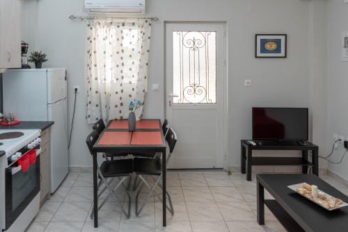 a kitchen with a table and a kitchen with a refrigerator at Kosta's Apartments in Vonitsa
