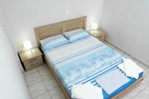 a small bedroom with a bed and two night stands at Kosta's Apartments in Vonitsa