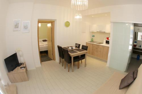 a kitchen and dining room with a table and chairs at Zadar Street Apartments and Room in Zadar