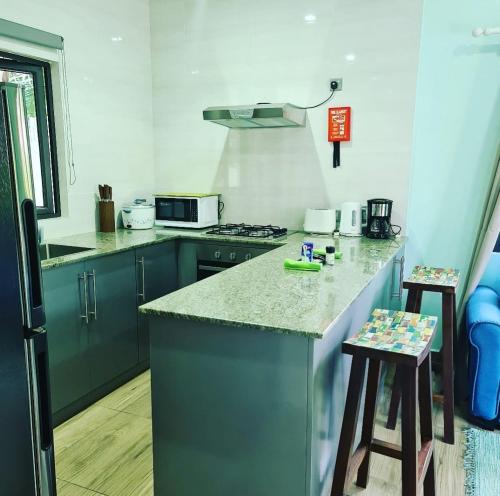 eine Küche mit blauen Schränken und einer Arbeitsplatte in der Unterkunft Casa De Leela Self Catering Guest House in La Digue
