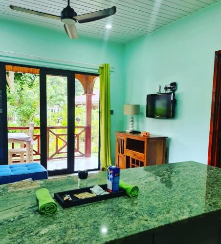 a kitchen with a green counter top and a table at Casa De Leela Self Catering Guest House in La Digue