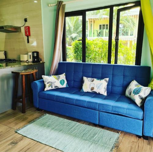 a blue couch in a living room with a window at Casa De Leela Self Catering Guest House in La Digue