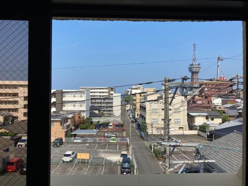 a view of a city from a window at J-Hoppers Beppu Guesthouse ジェイホッパーズ別府ゲストハウス in Beppu