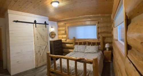 a bedroom with a bed in a log cabin at Cougar Mountain Lodge B&B in Valemount