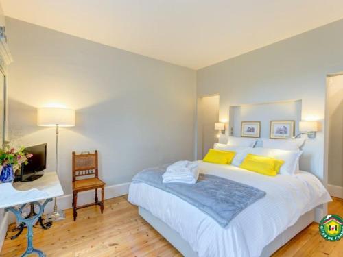 尚蒂伊的住宿－Appartement Chantilly, 3 pièces, 4 personnes - FR-1-526-3，一间卧室配有一张带黄色枕头的大床和一张书桌