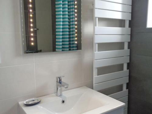 een witte badkamer met een wastafel en een spiegel bij Gîte Maringes, 3 pièces, 4 personnes - FR-1-496-174 in Maringes