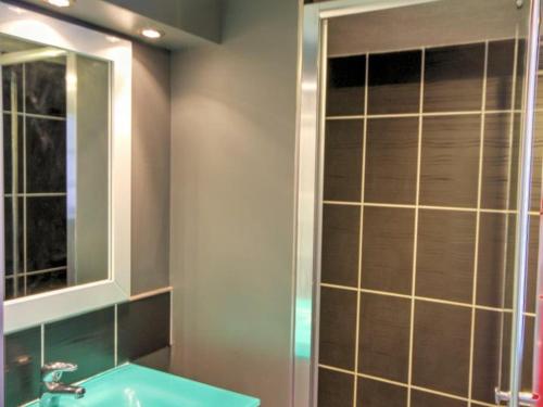 uma casa de banho com um lavatório, um espelho e um chuveiro em Gîte Malleval, 2 pièces, 2 personnes - FR-1-496-116 em Malleval