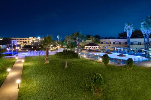 a resort with a pool at night at Olive Garden Hotel in Lardos