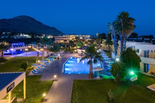 a view of a resort with a pool at night at Olive Garden Hotel in Lardos