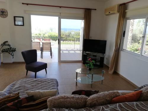 a living room with a couch and a tv at Gabriella in Peyia