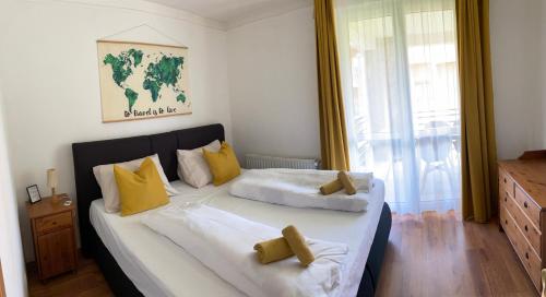 - une chambre avec un grand lit et des oreillers jaunes dans l'établissement Bad-Bük Golf & Wellnes Apartman Villapark, à Bük