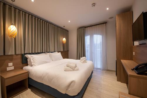 a hotel room with a large bed and a television at Bliss Boutique Living in Xagħra