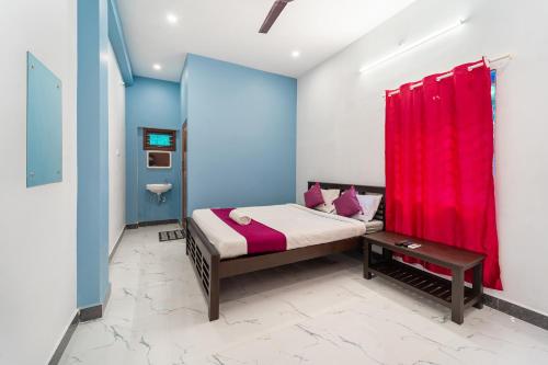 a bedroom with a bed with a red curtain at Pavisha Farm House Swimming Pool in Pondicherry