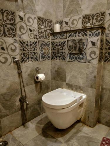 a bathroom with a white toilet in a room at Dwivedi Hotels Sri Omkar Palace in Varanasi