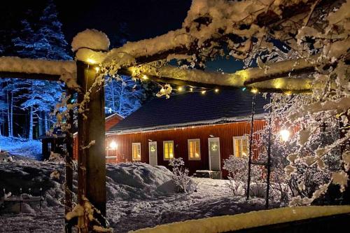 a house covered in snow at night with lights at Projekt Schwedenalm in Furudal
