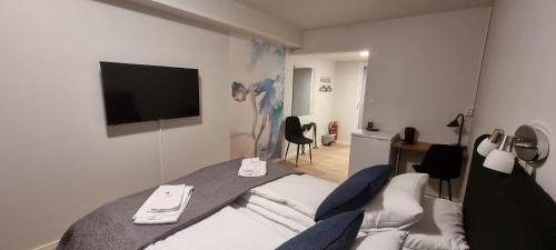 una camera d'albergo con letto e TV di Husnes Sentrum Hotell a Husnes
