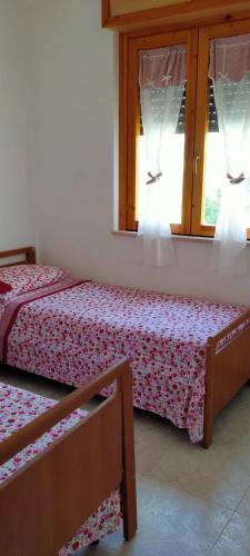 dwa łóżka w pokoju z dwoma oknami w obiekcie Residence Mediterranea w mieście Campomarino