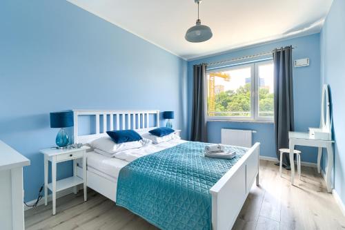 a blue bedroom with a bed and a desk at EXCLUSIVE Nautica PREMIUM Apartments in Szczecin