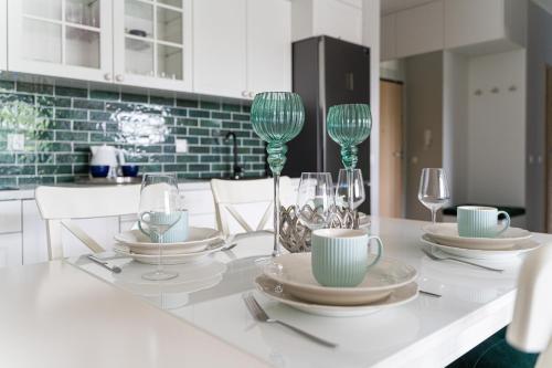 a table with plates and wine glasses on it at EXCLUSIVE Nautica PREMIUM Apartments in Szczecin