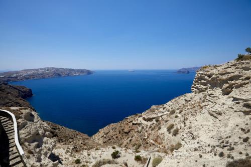 a bench on the side of a mountain overlooking a blue lake at Thermes Luxury Villas And Spa in Megalokhori