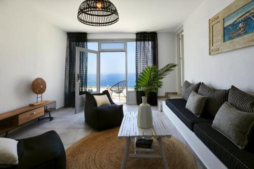 a living room with a couch and a table at Thermes Luxury Villas And Spa in Megalokhori