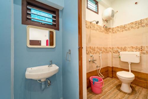 a blue bathroom with a toilet and a sink at Pavisha Farm House Swimming Pool in Pondicherry