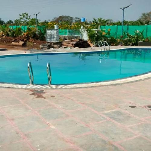 a large swimming pool with blue water at Sentosa Farms in Chinchavli