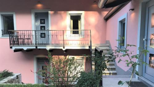 un edificio rosa con balcone e scale di Vila Burbonka a Nova Gorica