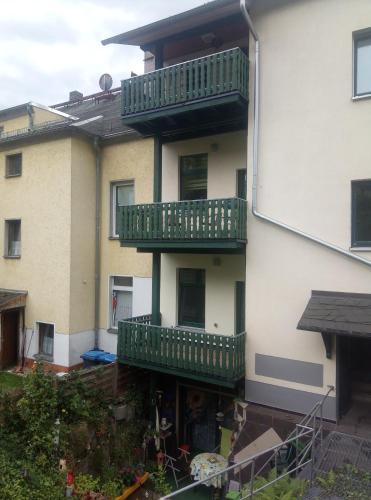 a building with green balconies on the side of it at Ferienwohnung Eddi in Reichenbach im Vogtland