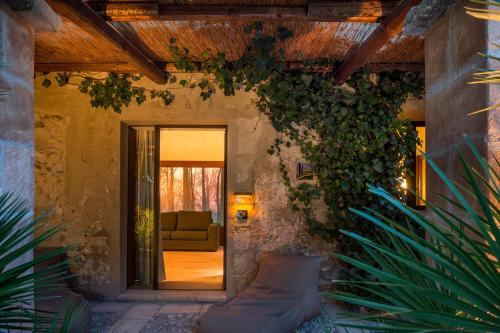 eine Tür, die zu einem Wohnzimmer mit einem Sofa führt in der Unterkunft Baglio La Porta by Geocharme in San Vito lo Capo